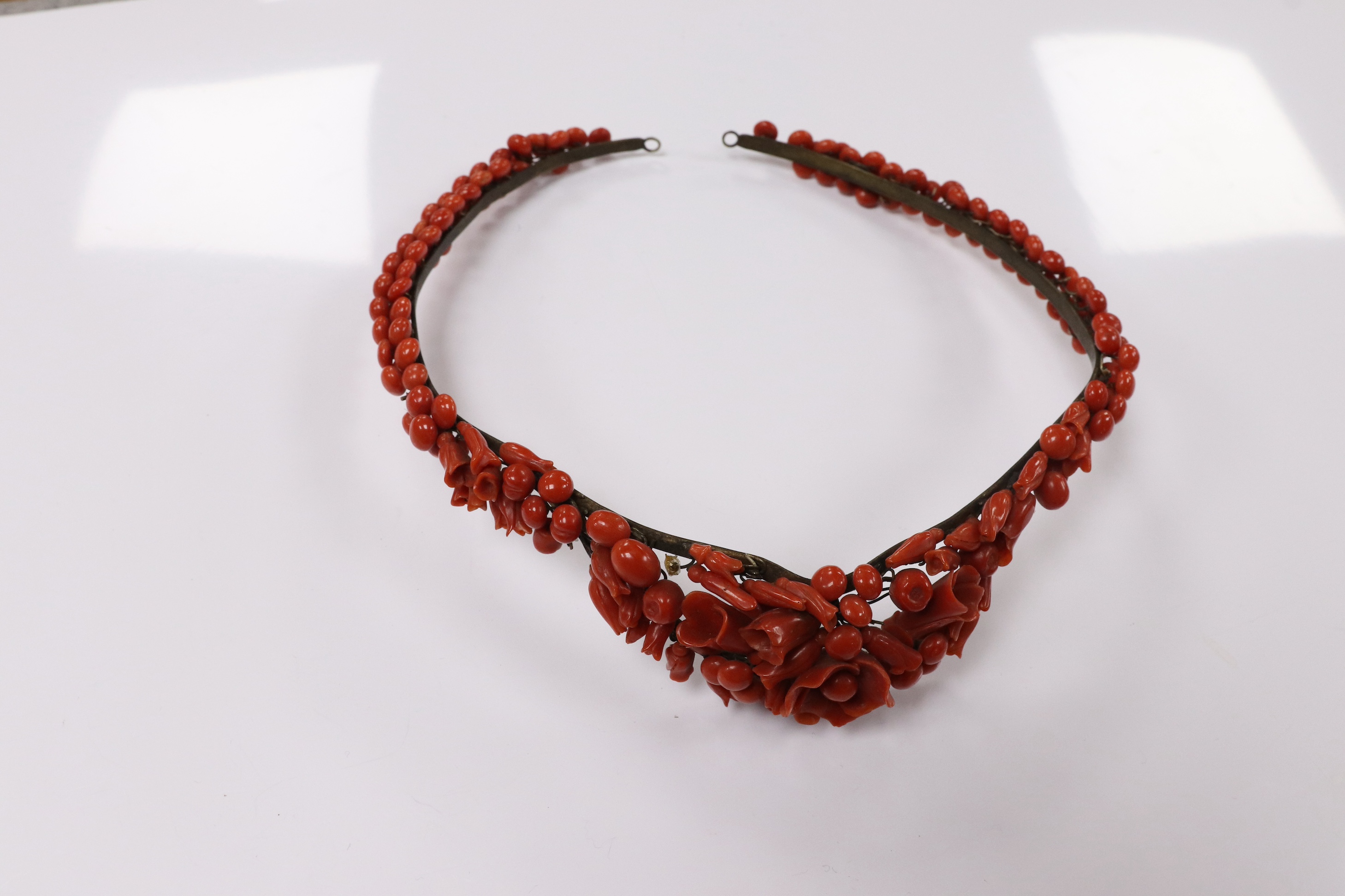 A 19th century base metal and coral bead floral designed tiara, approximately 40cm. Condition - poor to fair (some coral detached pieces in a small bag)